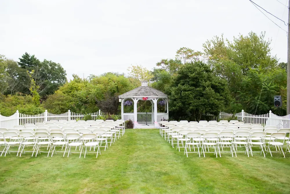 The lakeside gazebo with white chairs set for a ceremony